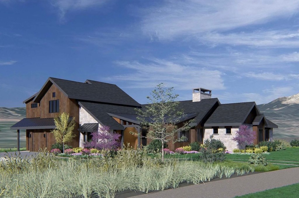 A modern house with wooden and stone exterior situated amidst lush landscaping and colorful flowers, under a blue sky.